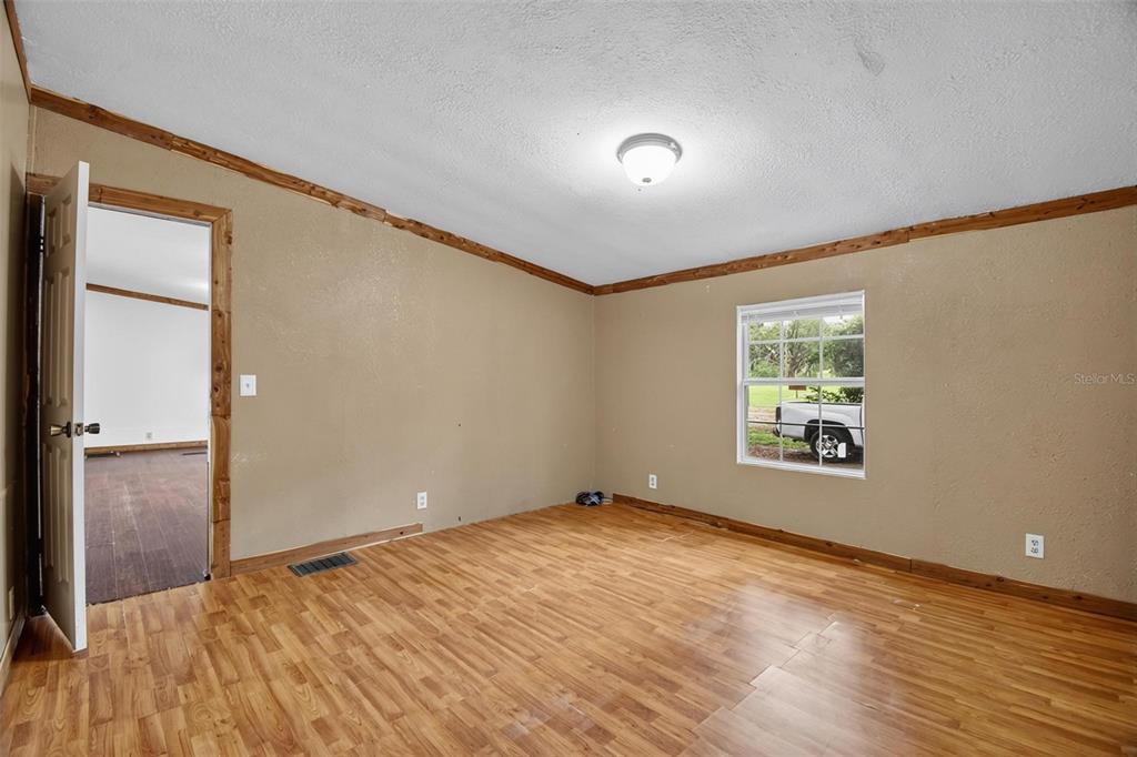 156 Kingfish Road Pomona Park, FL 32181 - Photo 19 of 55 a view of an empty room with wooden floor and a window