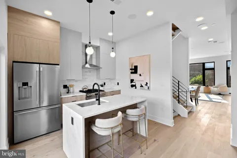 a kitchen with a sink appliances and wooden floor