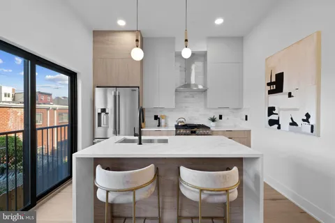 a kitchen with granite countertop a sink a center island and chairs