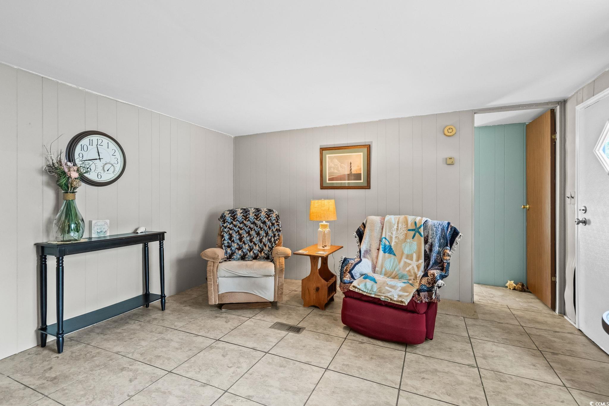 4516 Willet Street North Myrtle Beach, SC 29582 - Photo 13 of 40 Living area featuring tile patterned floors and wooden walls