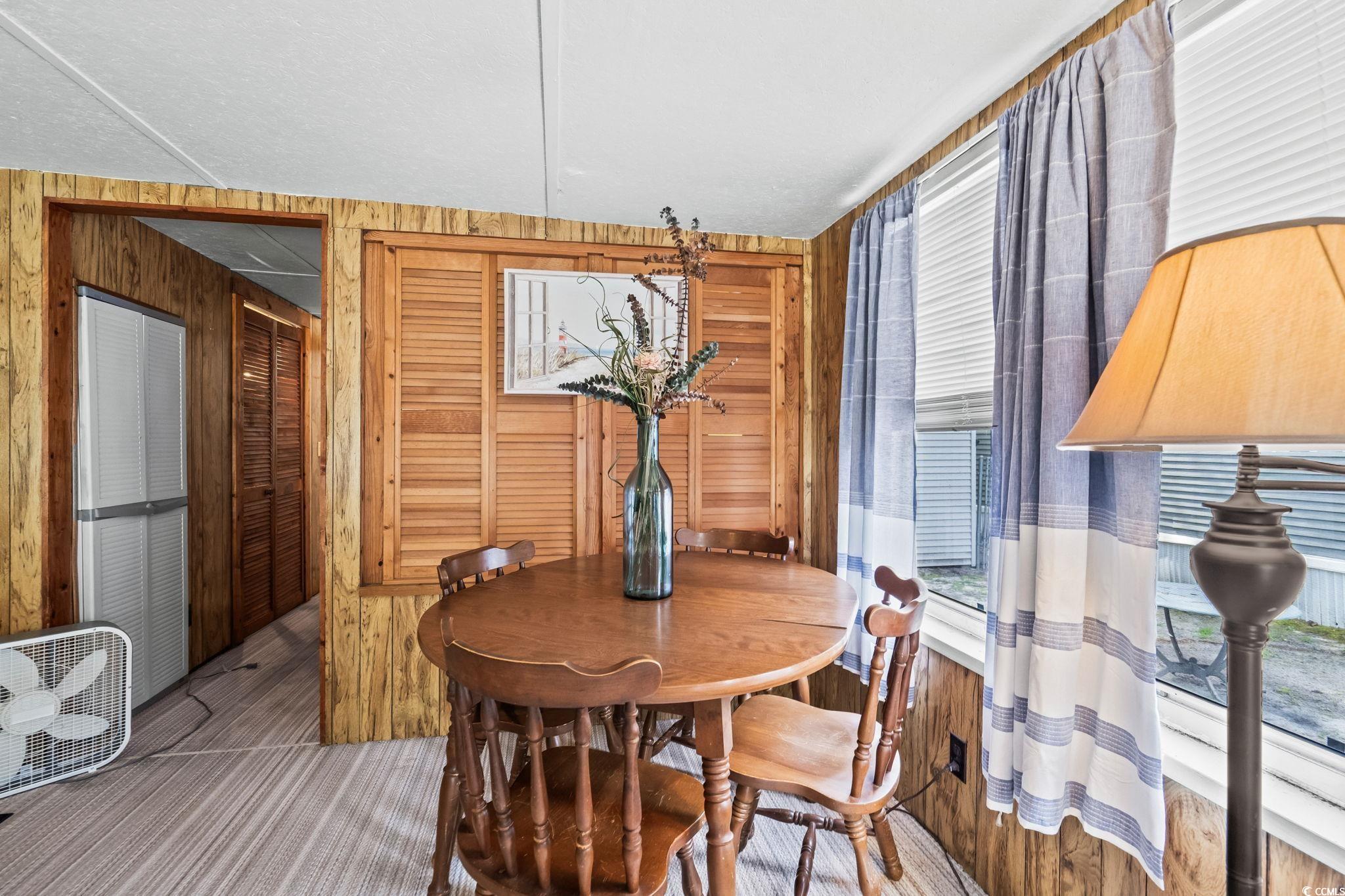4516 Willet Street North Myrtle Beach, SC 29582 - Photo 21 of 40 Carpeted dining area featuring wood walls