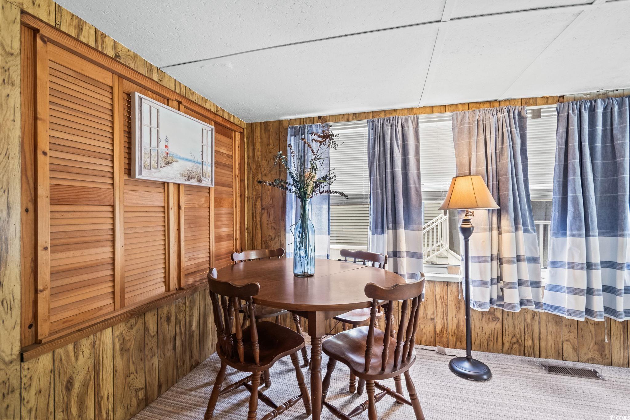 4516 Willet Street North Myrtle Beach, SC 29582 - Photo 22 of 40 Carpeted dining area with wood walls