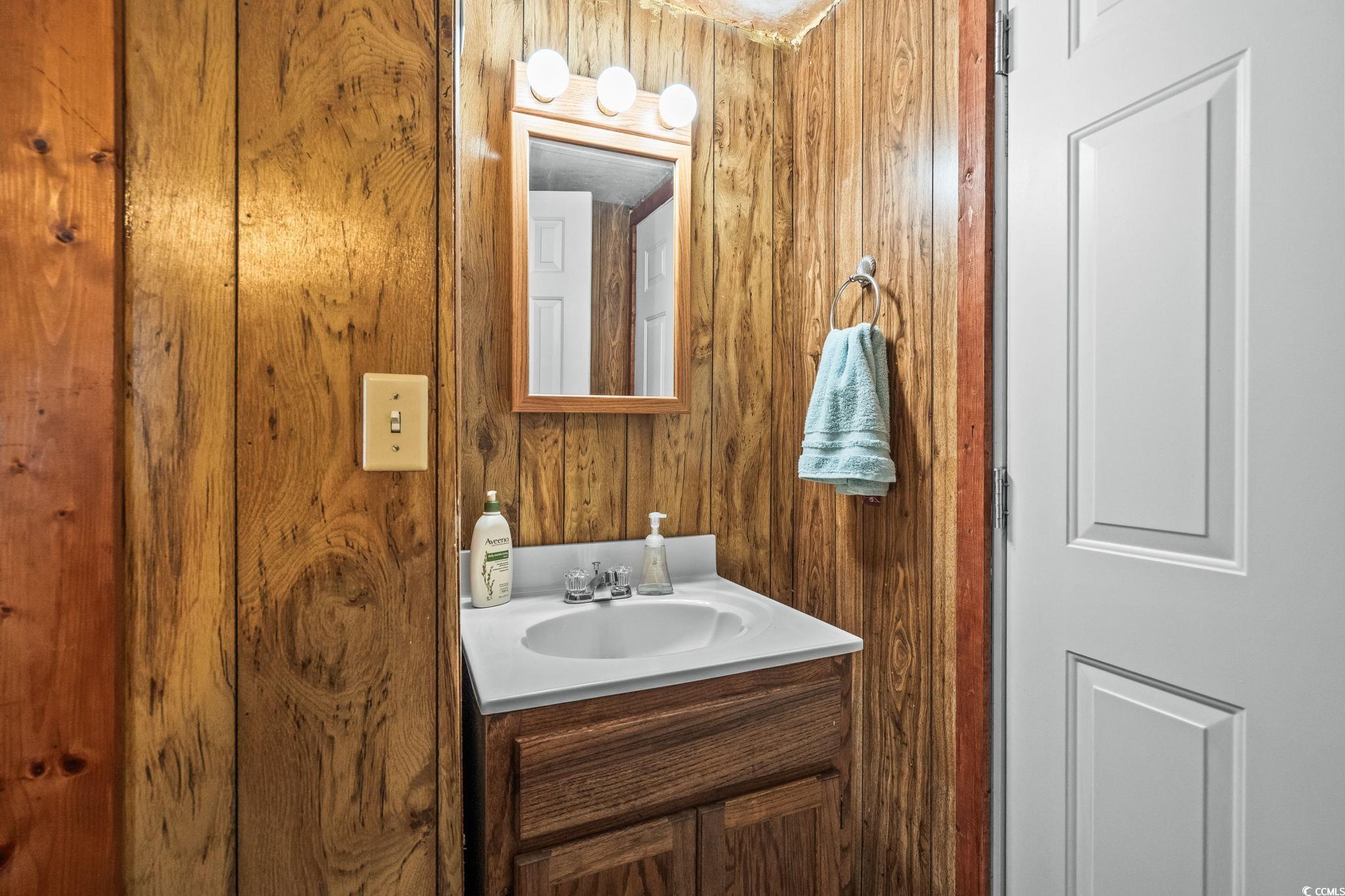 4516 Willet Street North Myrtle Beach, SC 29582 - Photo 26 of 40 Half bath featuring wood walls and vanity