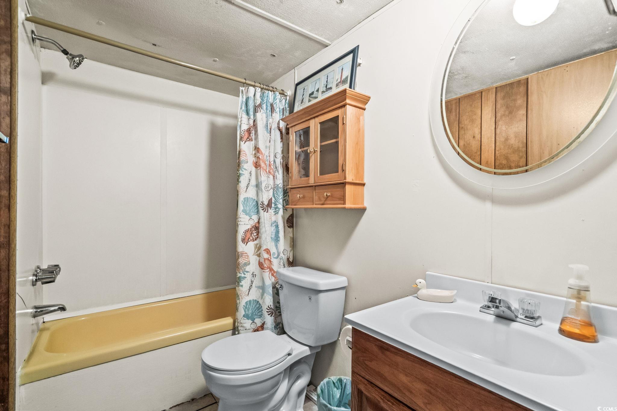 4516 Willet Street North Myrtle Beach, SC 29582 - Photo 30 of 40 Full bathroom featuring shower / tub combo with curtain, vanity, and a textured ceiling