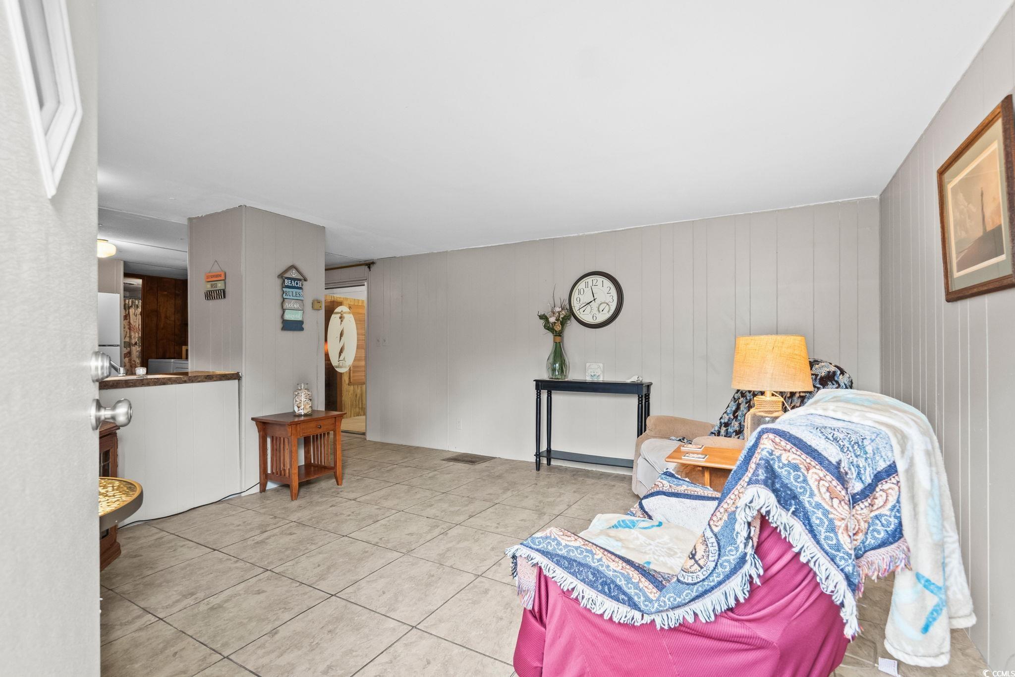 4516 Willet Street North Myrtle Beach, SC 29582 - Photo 10 of 40 Living area with light tile patterned floors and wood walls