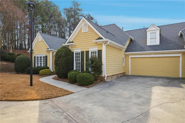 a view of a house with garage and plants