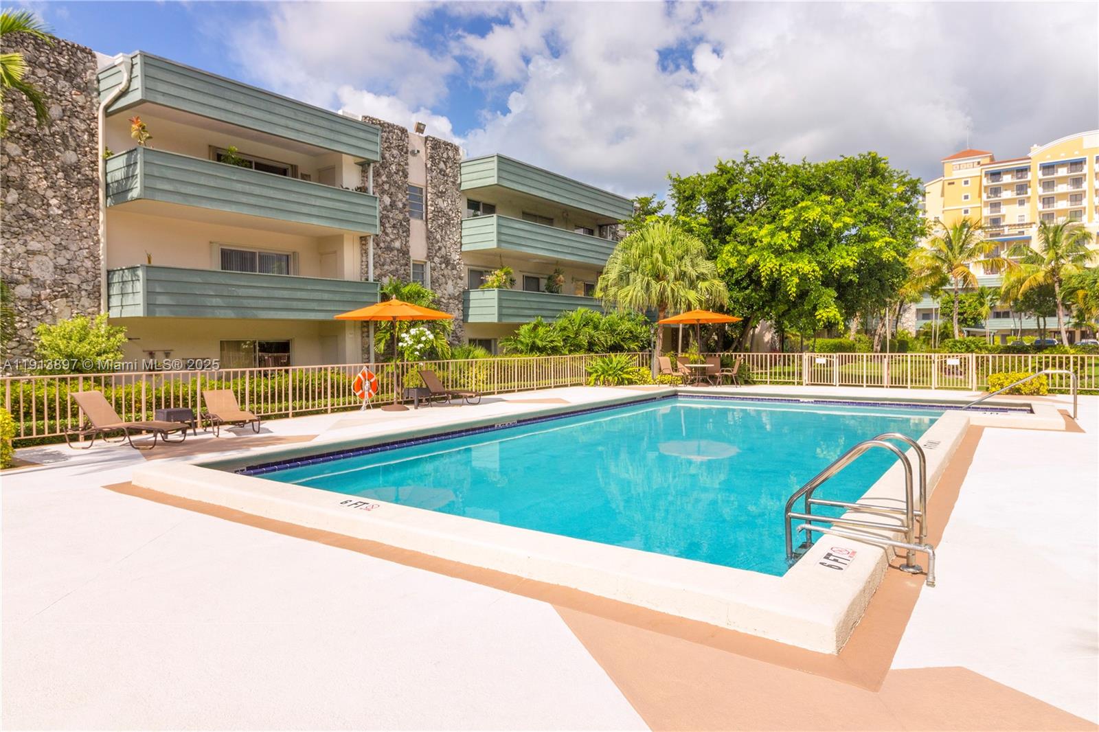 8305 Southwest 72nd Avenue, Unit 105A Miami, FL 33143 - Photo 14 of 25 a view of a swimming pool with a lawn chairs under an umbrella