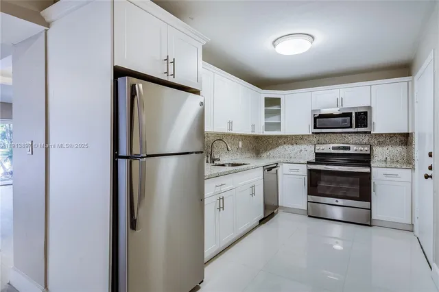 a kitchen with cabinets stainless steel appliances and a counter space