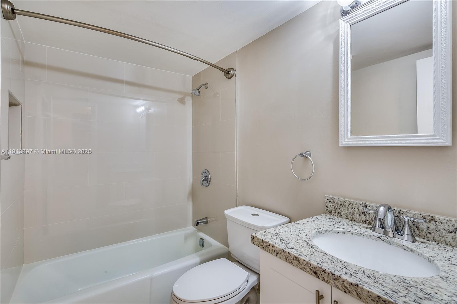 8305 Southwest 72nd Avenue, Unit 105A Miami, FL 33143 - Photo 8 of 25 a bathroom with a granite countertop sink toilet and shower