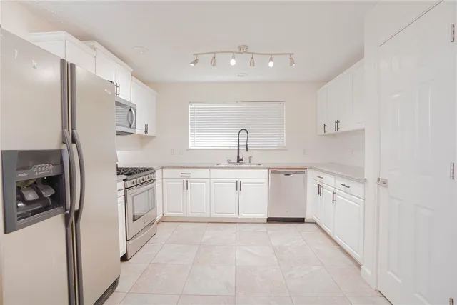 a kitchen with white cabinets and white appliances