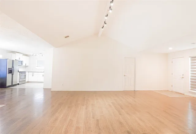 a view of an empty room with wooden floor