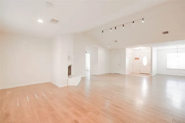 a view of an empty room with wooden floor