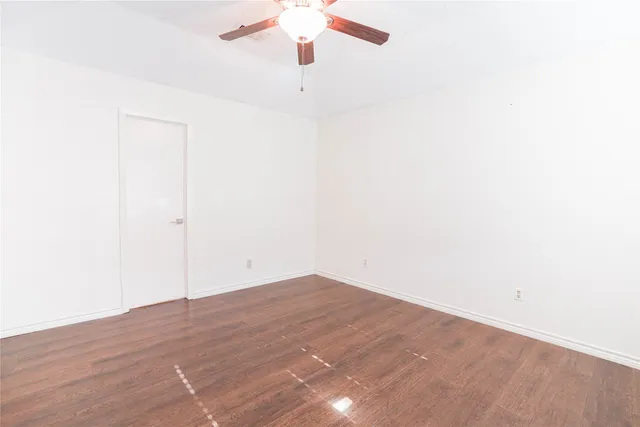 an empty room with a ceiling fan and a window