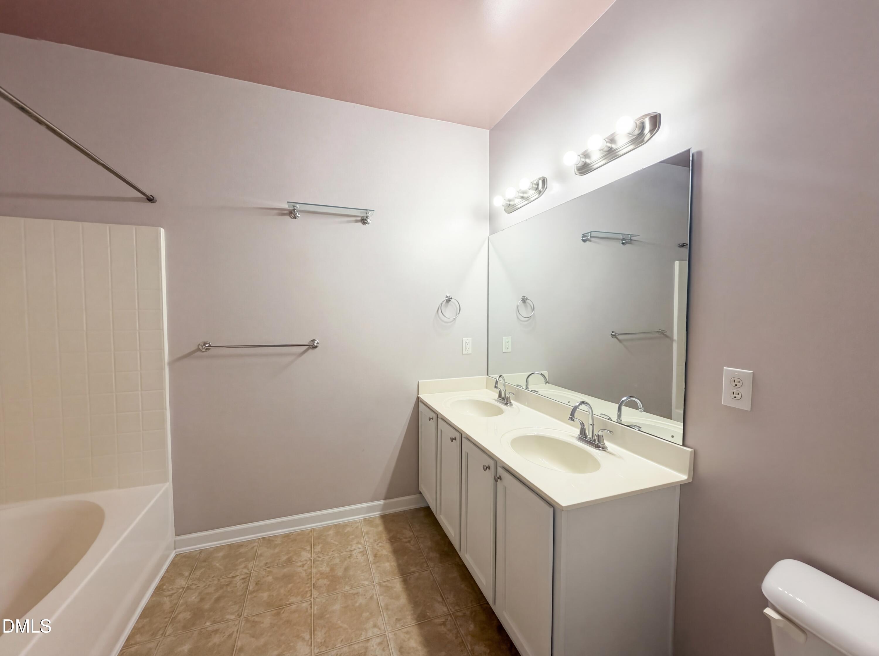 3712 Mayfair Mill Drive Raleigh, NC 27616 - Photo 6 of 16 a bathroom with a sink mirror and a bathtub