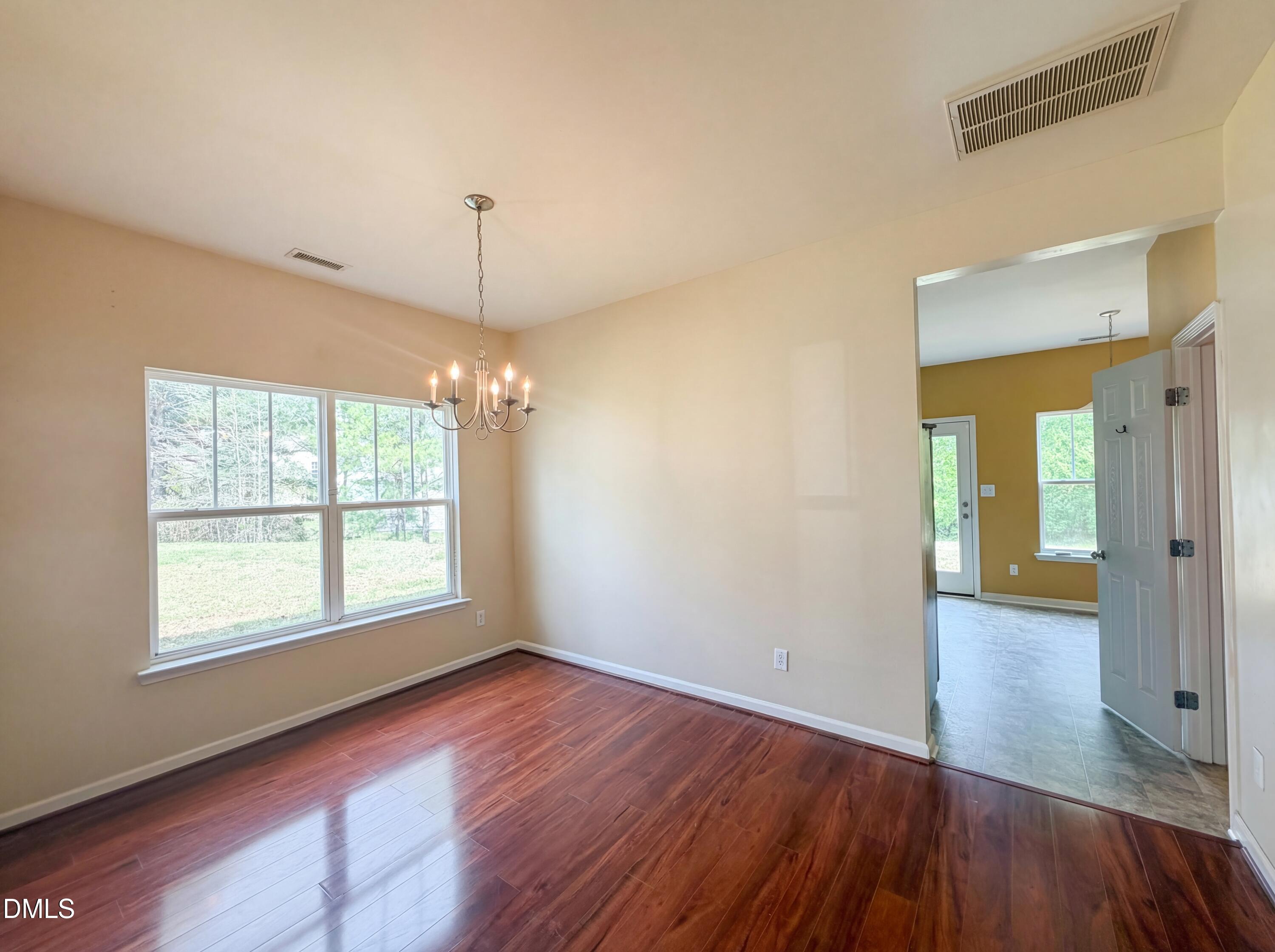 3712 Mayfair Mill Drive Raleigh, NC 27616 - Photo 7 of 16 a view of an empty room with glass door and wooden floor