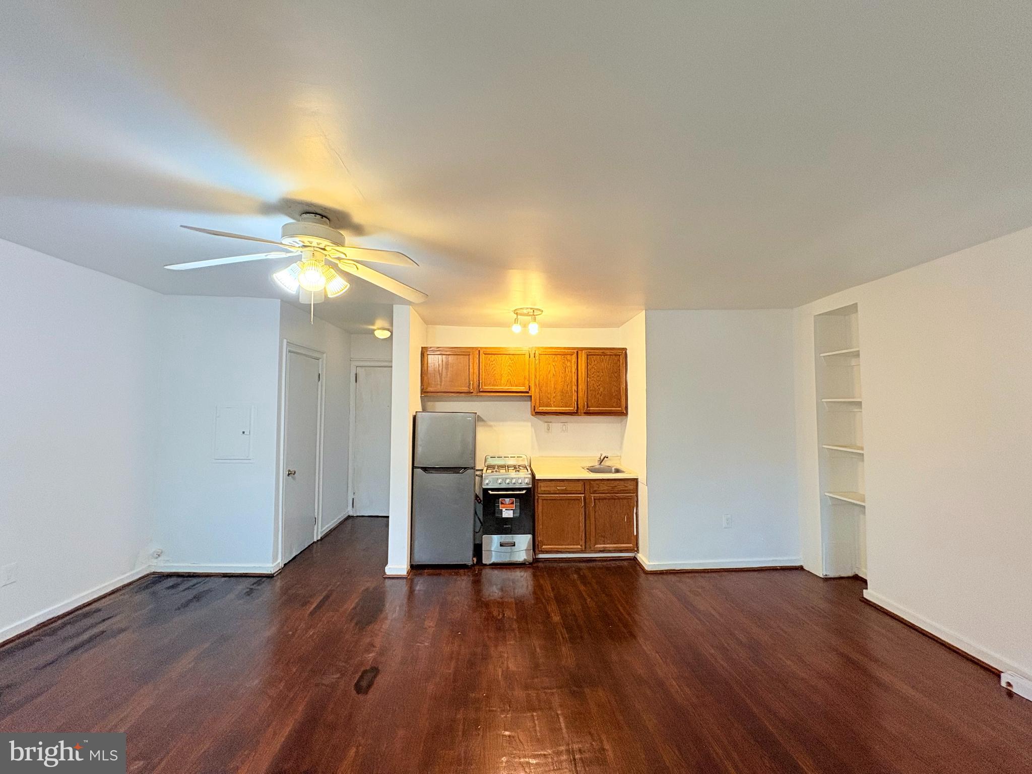 916 Clinton Street, Unit 3F Philadelphia, PA 19107 - Photo 3 of 15 a view of a room with wooden floor a ceiling fan and staircase