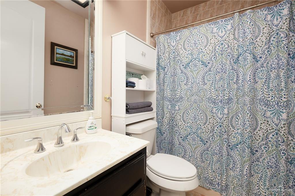 23725 North Val Verde Road Edinburg, TX 78542 - Photo 21 of 36 a bathroom with a sink a toilet and shower curtain