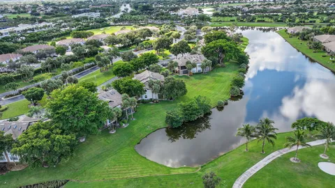 a view of a white house with a big yard and potted plants