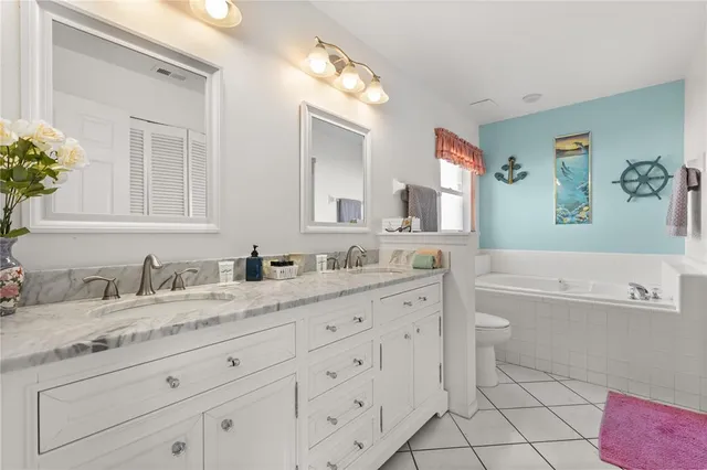 a bathroom with a granite countertop sink mirror vanity and toilet