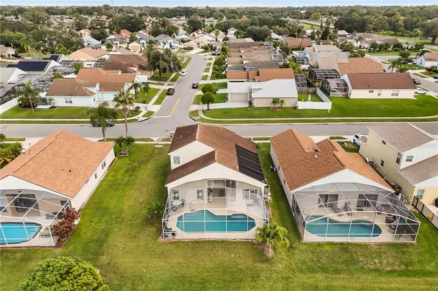 an aerial view of residential houses with outdoor space and swimming pool
