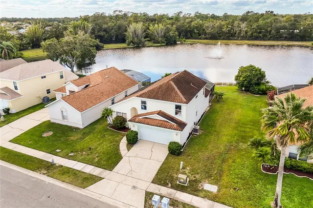 an aerial view of a house with pool and lake view