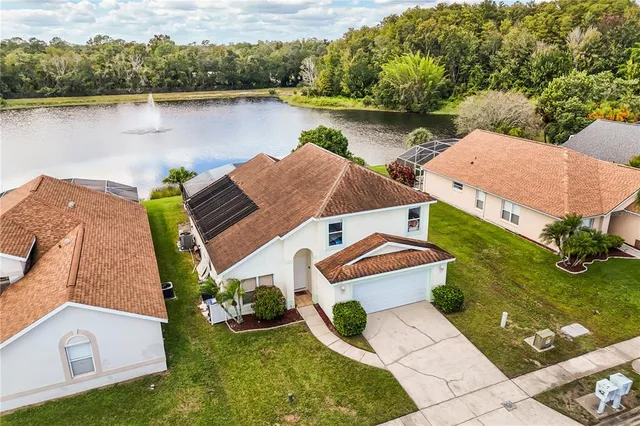 an aerial view of a house with outdoor space and lake view
