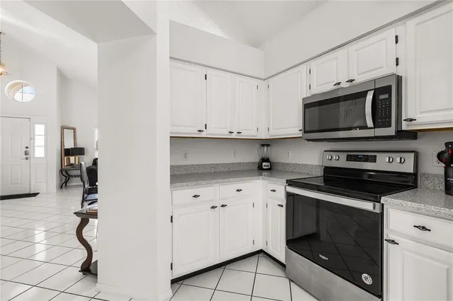 a kitchen with granite countertop white cabinets stainless steel appliances and sink