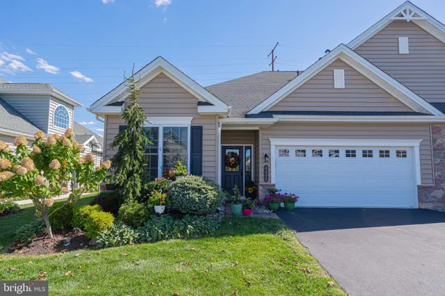 a front view of a house with a garden and plants