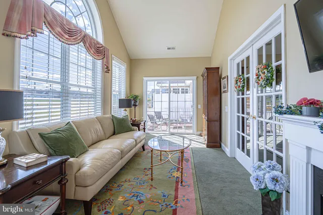a bedroom with a large bed a chandelier and dresser