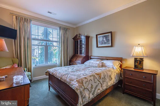 a spacious bedroom with a bed a couch and a flat screen tv