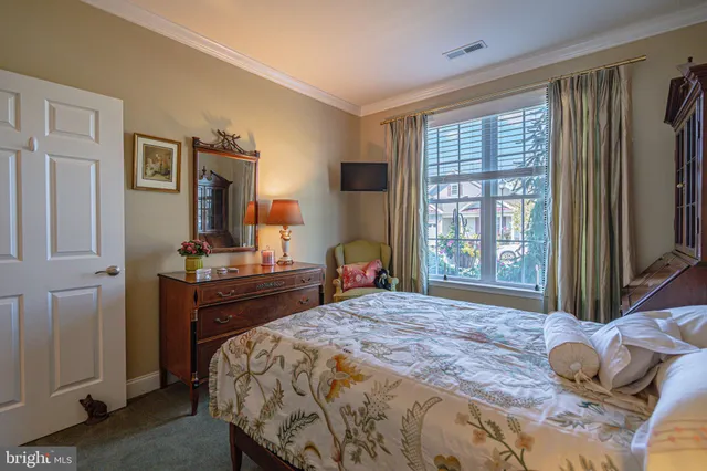 a bedroom with a bed window and a flat tv screen