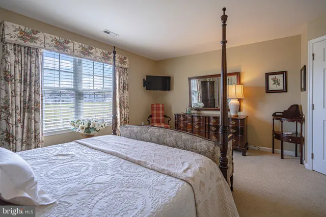 a living room with furniture a flat screen tv and a large window