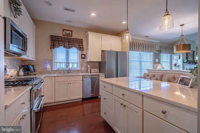 a kitchen with white cabinets and appliances