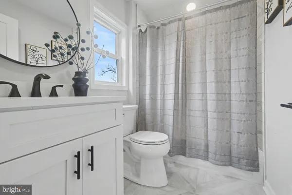 a bathroom with a toilet sink and shower curtain