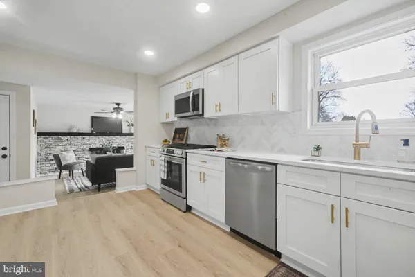 a kitchen with a refrigerator stove top oven and sink