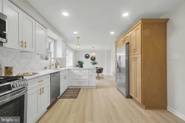 a large kitchen with stainless steel appliances granite countertop a lot of counter space and wooden floors