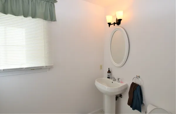 a bathroom with a sink a mirror and a window