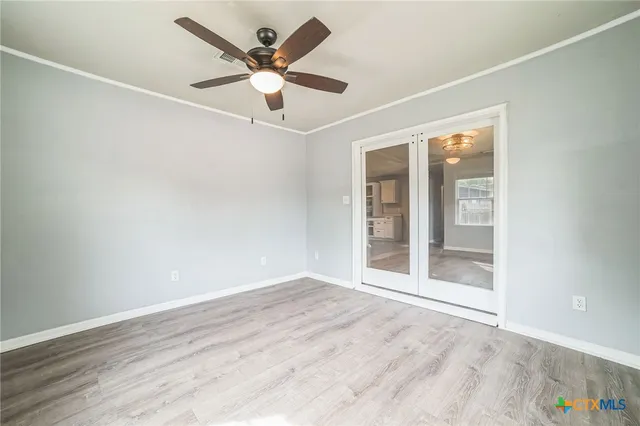 an empty room with wooden floor and windows