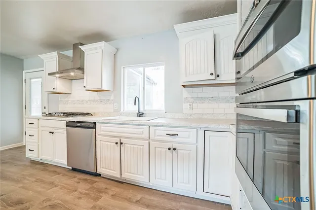 a kitchen with white cabinets and white appliances