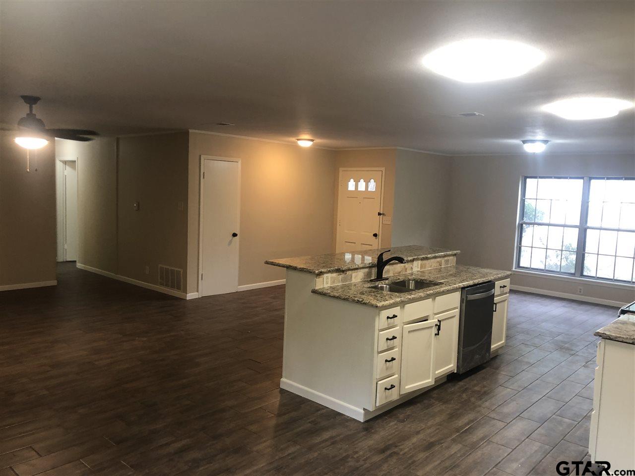 3001 South Robertson Avenue Tyler, TX 75701 - Photo 4 of 12 a kitchen with stainless steel appliances granite countertop a stove and a wooden floors