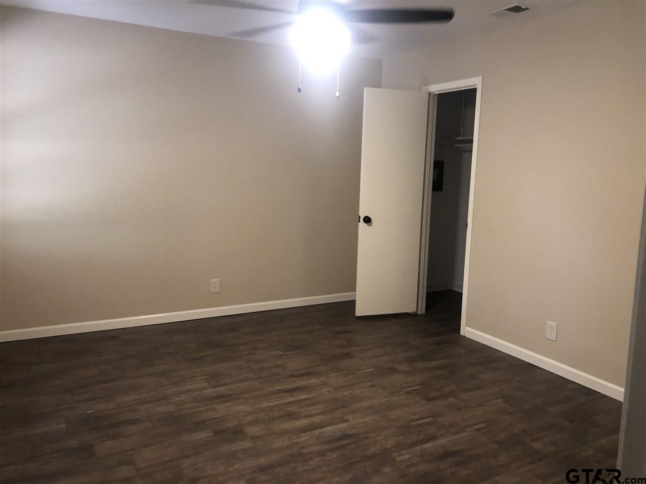 3001 South Robertson Avenue Tyler, TX 75701 - Photo 7 of 12 a view of an empty room with wooden floor and closet