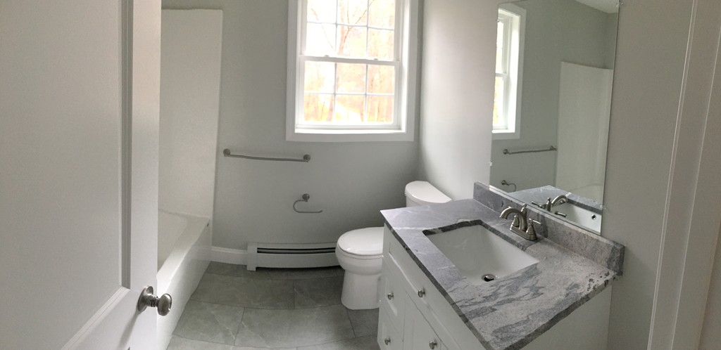 75 Baldwin Road Billerica, MA 01821 - Photo 30 of 30 a bathroom with a granite countertop sink a toilet and a window