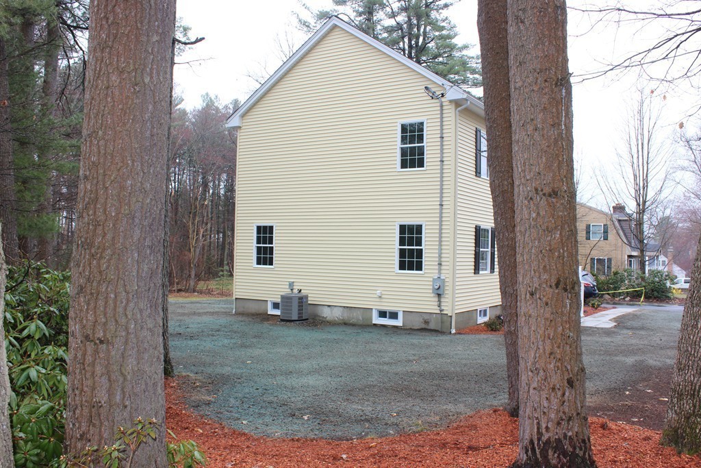 75 Baldwin Road Billerica, MA 01821 - Photo 4 of 30 a view of a white house next to a yard with large trees