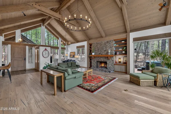 a living room with furniture large window and wooden floor