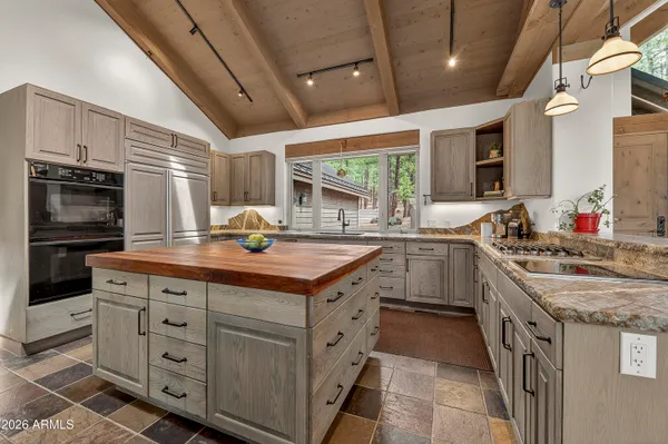 a kitchen with kitchen island granite countertop a sink stove and cabinets