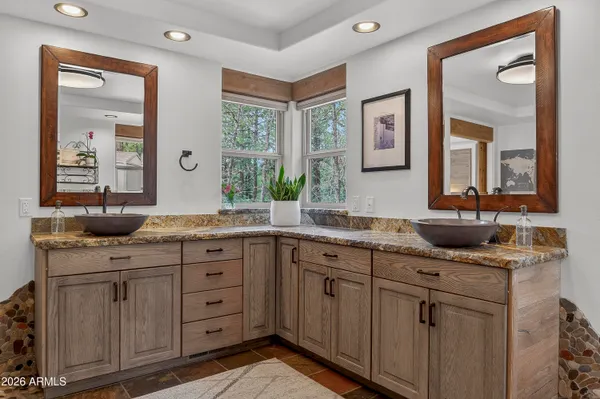 a en suite bathroom with a double vanity sink a mirror and shower