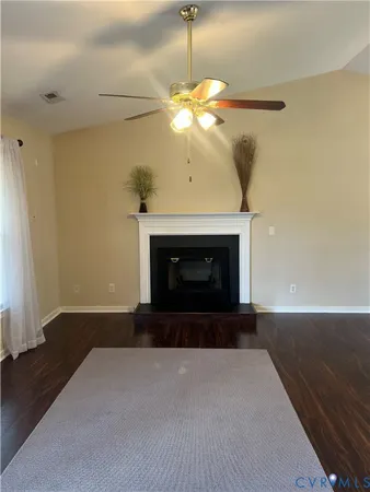 a view of an empty room with a fireplace and a window