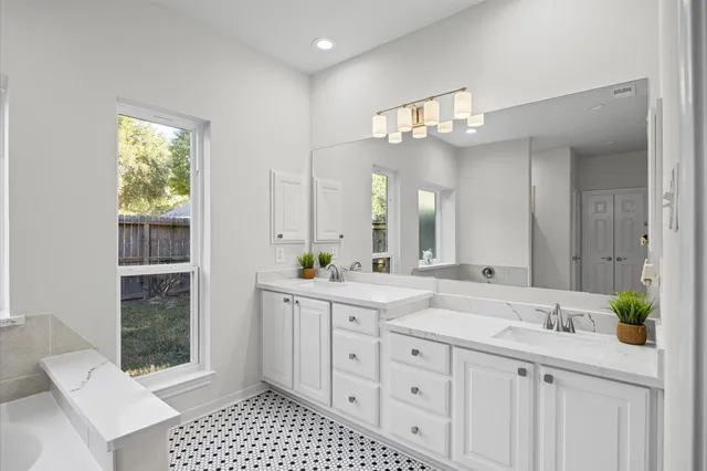a spacious bathroom with a shower a sink and a mirror