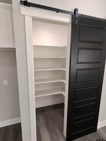 a view of walk in closet with empty racks