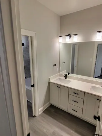 a spacious bathroom with a double vanity sink a mirror and a shower